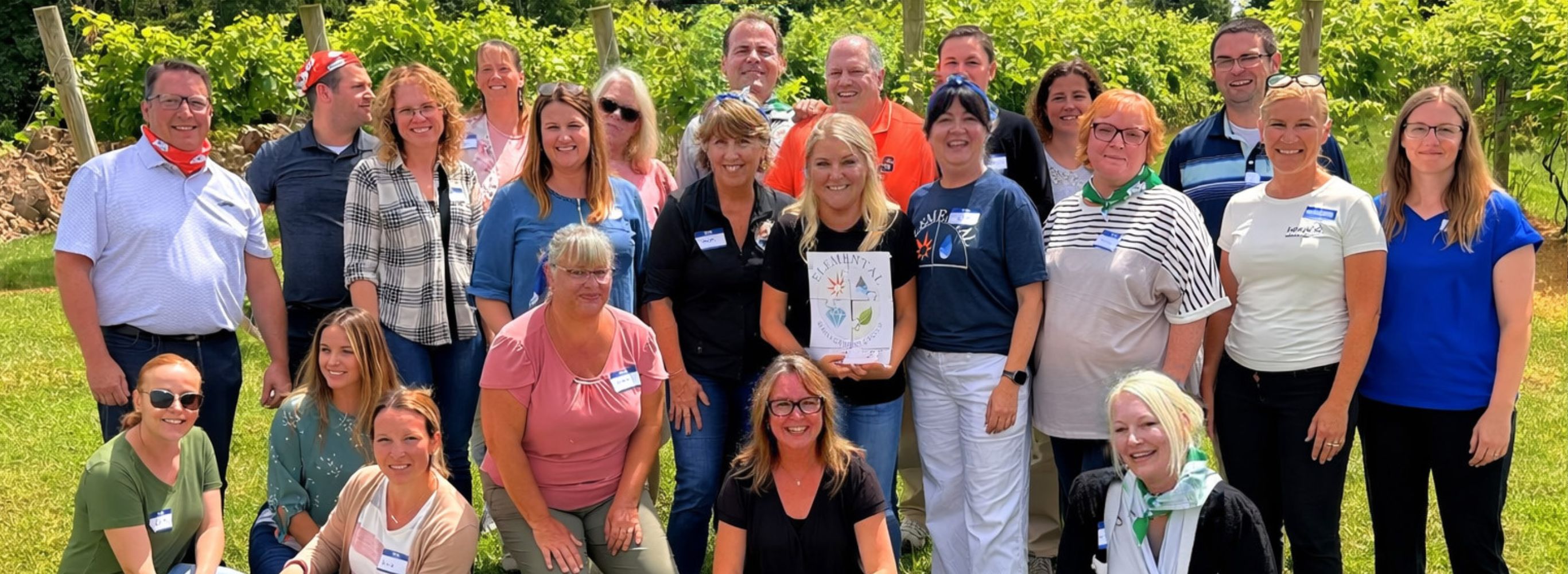 Many People posing for a picture in a field